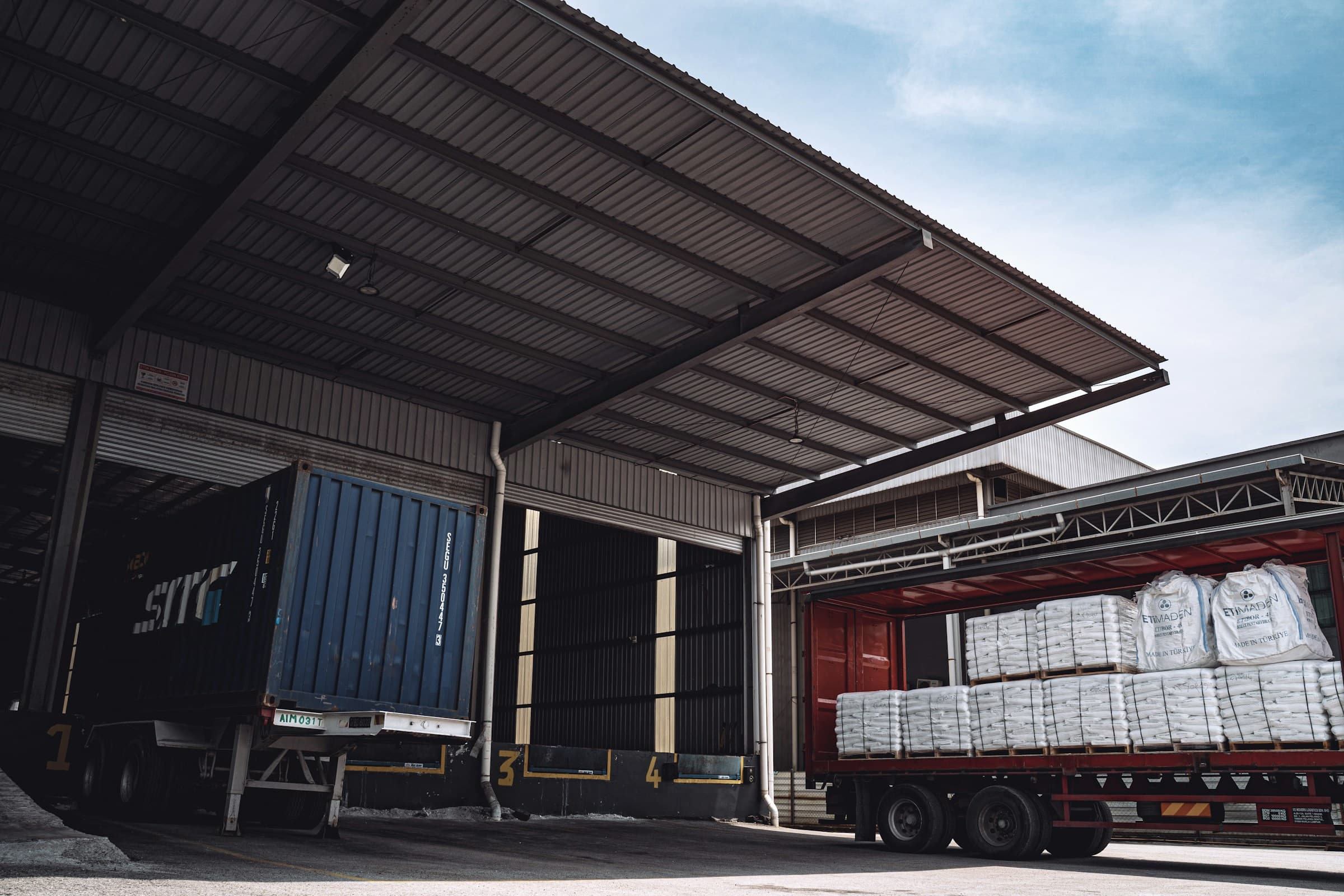 Loading dock with trucks at numbered warehouse bays